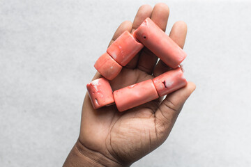 Overhead view of genuine pink coral beads in brown hands, top view of large stringed pink coral beads