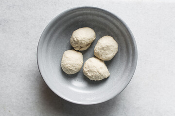 Overhead view of noodles dough  in a grey bowl, top view of homemade biang biang noodles, process of making hand pulled noodles