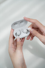 Close up of woman is open the white wireless earbuds case