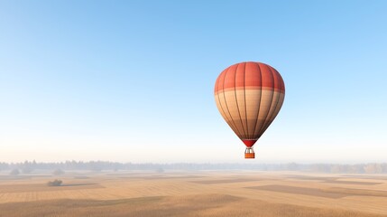 Obraz premium A colorful hot air balloon soaring above scenic fields under a clear blue sky, capturing the essence of adventure and leisure in vibrant colors.