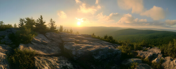 A serene sunset over a mountainous landscape with lush greenery and rocky terrain.