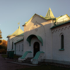 Brick building of the Ratnaya Palata museum in Pushkin city, glowing in bright sunset light under a...