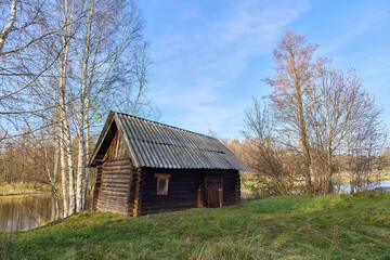 Abandoned Russian Bathhouse with Birches by Autumn River