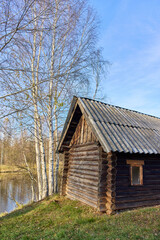Fototapeta premium Abandoned Russian Bathhouse with Birches by Autumn River