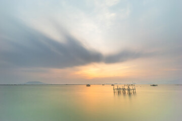 Fototapeta premium Tranquil Evening Sea with Stunning Sunset Glow. Bagan Traditional Structure is one of the Fishermen's Resting Places at Sea.