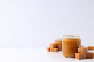 Cubes of salted caramel with caramel in a jar