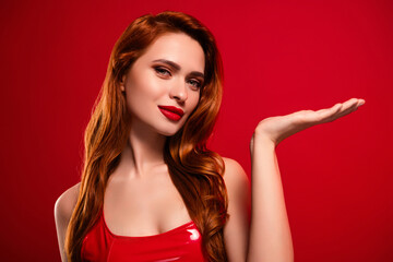 Photo of lovely attractive lady hold empty space dressed sexy leather garment isolated on red color background