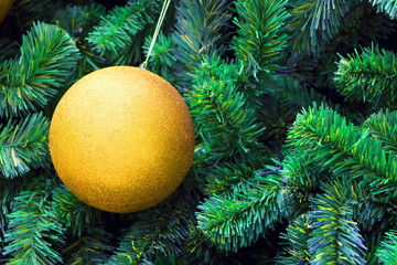 Close up decoration hanging on Christmas tree branches by yellow bauble ball, have copyspace