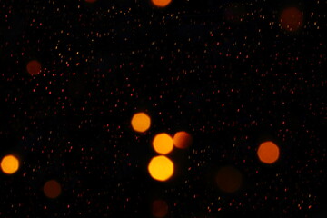 Many soft orange blurry bokeh light with many red blurry dot light on dark background in Christmas and New Year festival day, can use for background, have copysapce