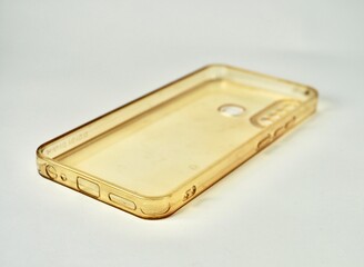 Old and aged dirty clear transparent smartphone case turning yellow isolated on horizontal plain...