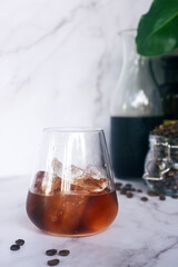 a glass of homemade cold brew coffee with ice on rusty table background