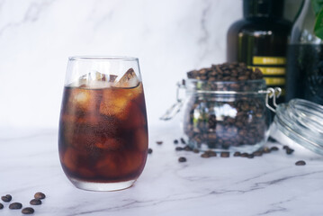 a glass of homemade cold brew coffee with ice on rusty table background