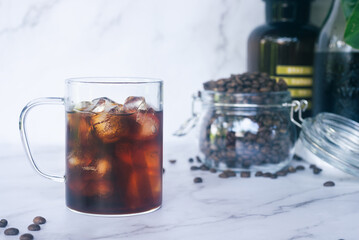 a glass of homemade cold brew coffee with ice on rusty table background