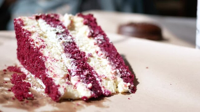 cutting A piece of purple velvet cake with cream 