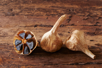 Black garlic on old wooden board