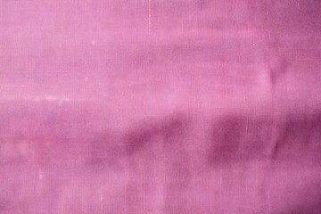 A close-up of a textured pink fabric, showcasing its smooth surface and color depth.