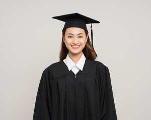 Happy asian woman in graduation costume with cap on isolated background. College degree successful...