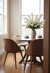 A cozy dining room with a wooden table and chairs, a vase of white flowers, and a framed artwork on the wall.