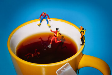 divers jumping in a tea cup to save woman in bikini drowning in the water, tea bag on the side