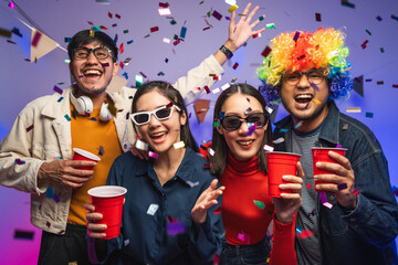 Fototapeta premium New Year's Party. Group of asian friend party in the house with disco light having fun and dancing together. Enjoy Singing karaoke listening music drinking beer celebration in new year happy hour.