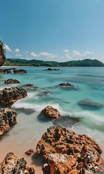 Beach with rocks and sea, in the background there is landscape, clear sky, daylight, bright colors, summer vibes, beautiful scenery,


