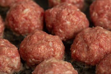 Meat balls are fried in a frying pan in vegetable oil