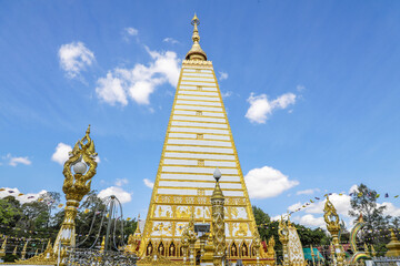 Fototapeta premium Wat Phra That Nong Bua, Ubon Ratchathani, inside there is the Phra That Sri Maha Bodhi Chedi, a replica of the Chedi in Bodh Gaya, India, stucco sculptures, candles, and two large Naga statues.