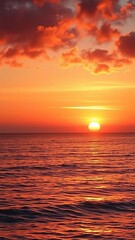 Fototapeta premium Vibrant orange and pink hues illuminate the sky as the sun rises over the calm sea, casting a golden glow on the water and creating a serene and breathtaking scene, beauty, nature