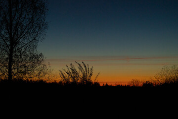 Beautiful colorful autumn sunrise skies over the rural landscape of Latvia. Seasonal scenery of Northern Europe.