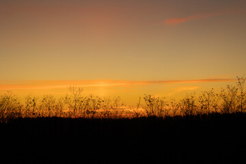 Beautiful colorful autumn sunrise skies over the rural landscape of Latvia. Seasonal scenery of Northern Europe.