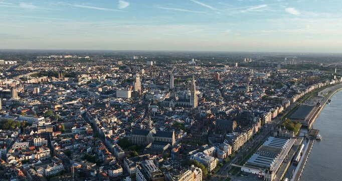 City view of Antwerp, Belgium at sunset. Skyline at the Schelde river. Aerial drone video, golden hour.