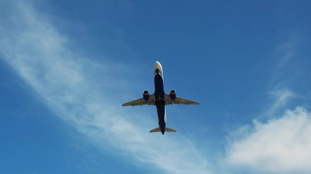 A plane glides across a bright blue sky, symbolizing the excitement of air travel. This scene embodies adventure and freedom, perfect for themes of journey and escape.