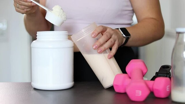 Close up of woman preparing a protein shake in the kitchen. Diet meal replacement for weight loss 