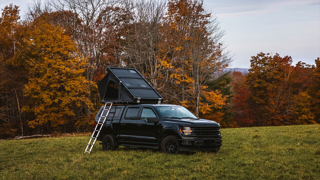 Truck with overlanding roof tent parked in Maine in the fall.
