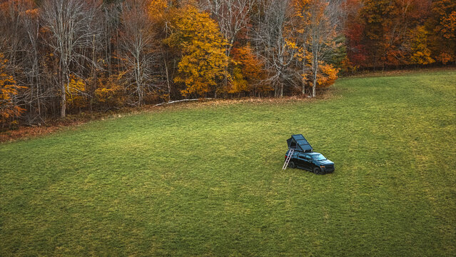 Aerial view of overlanding truck with tent and ladder at campsite