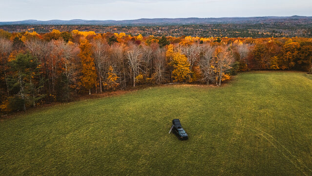 Overlanding truck parked in remote field campsite in Maine in fall