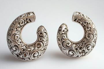 Obraz premium Pair of silver earrings showing floral ornaments on white background