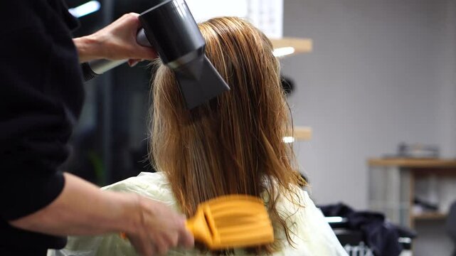Professional Hairdressing: Drying a girl's hair with a hairdryer in a beauty salon.  Professional Haircut and Styling for Woman.