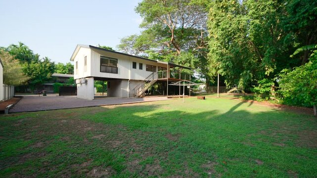 Two-story Darwin home exterior with spacious yard, great for real estate listings, dolly past tree over lawn to showcase open lawn, car park, and patio deck
