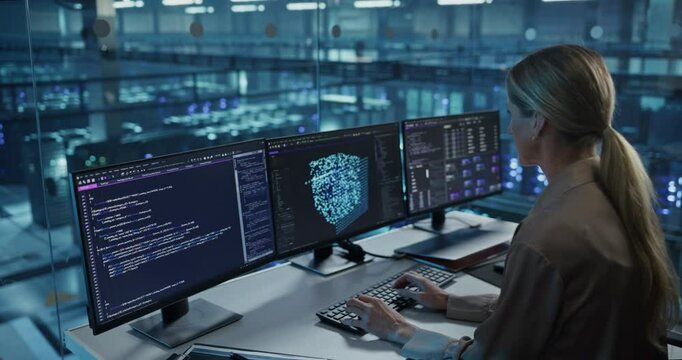 Female Developer Typing Software Code, Managing Several Open Screens Showing Editors and AI Model Diagnostics. Professional Reviewing Output for Errors in the Data Center Office