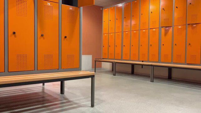 Orange locker room with numbered lockers 78 and 80 in the foreground, industrial metal and wood benches, and clean, calm environment for secure storage in gyms, sports facilities, or workplaces