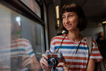 girl on train. A young girl uses a camera to take a picture of a beautiful view from the window...
