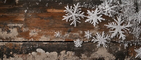 Fototapeta premium Delicate snowflakes resting on a rustic wooden surface, showcasing a contrast between the intricate patterns of snow and the texture of the wood.
