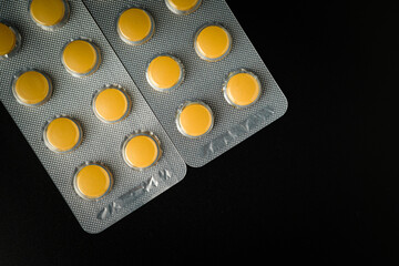 Brown Yellow Tablet pills blister Medicine on a black background