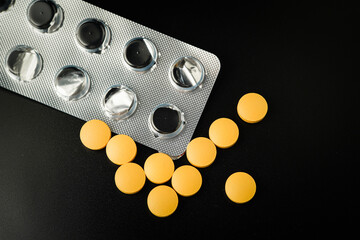 Pills Medicine tablet Brown Yellow in blister pack on a black background