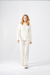 Cute young blonde girl posing standing on white background, copy space