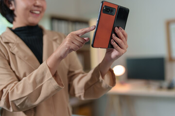 Attractive Asian businesswoman standing on the phone talking about real estate projects and chatting with happy smiles at the office.