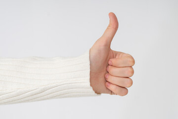 Women's hands making a thumbs up sign close up