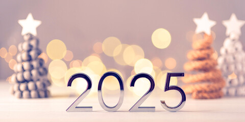 Metal numbers 2025 on table with bokeh lights.