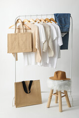 A bag hangs on a hanger with clothes